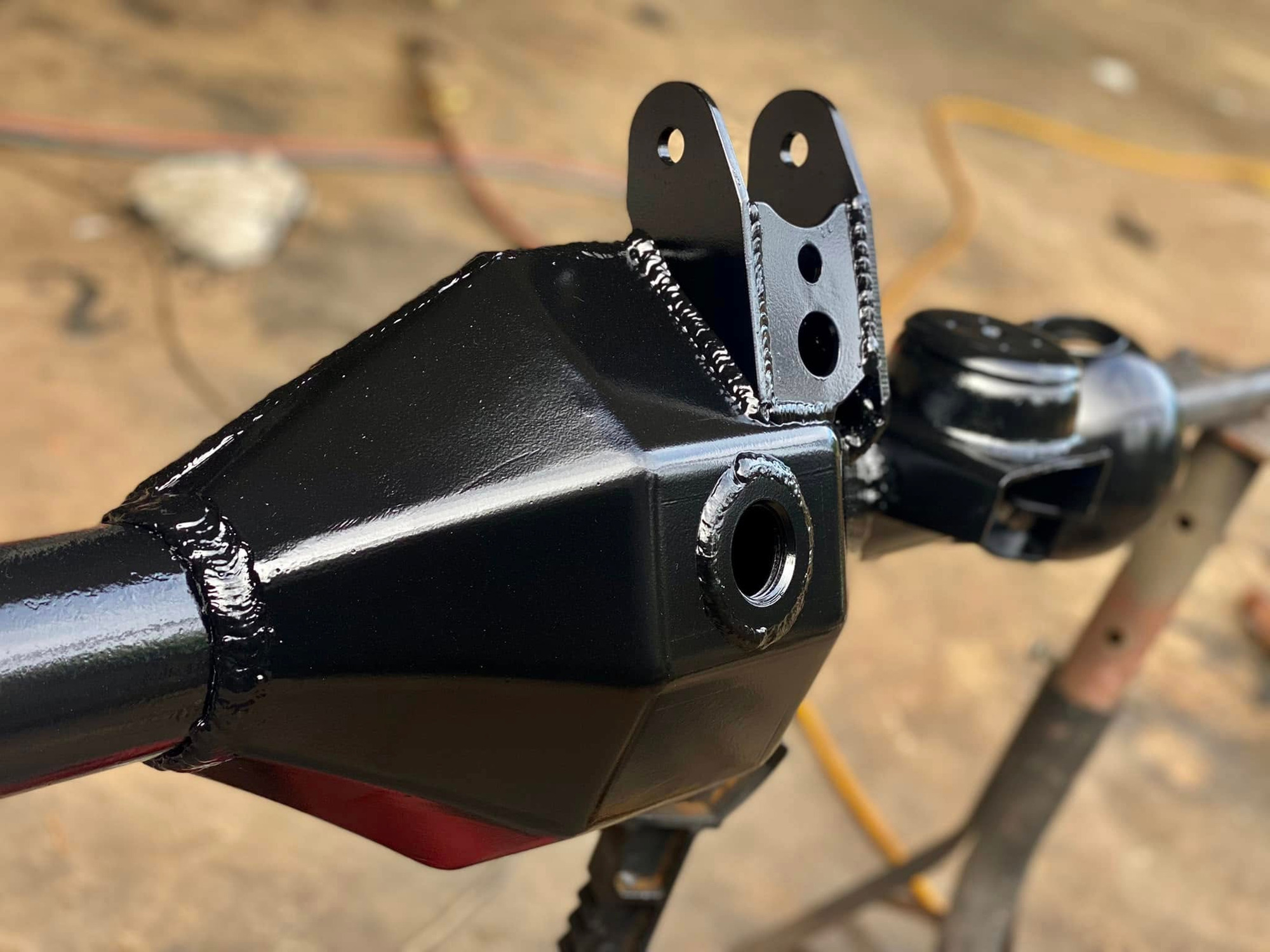 Custom axle bracket detail with fresh welds