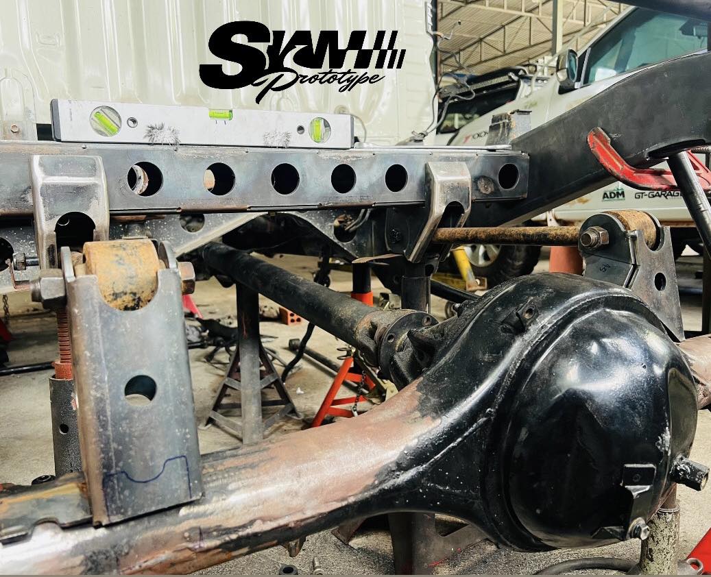 Axle with fabricated coil spring mount